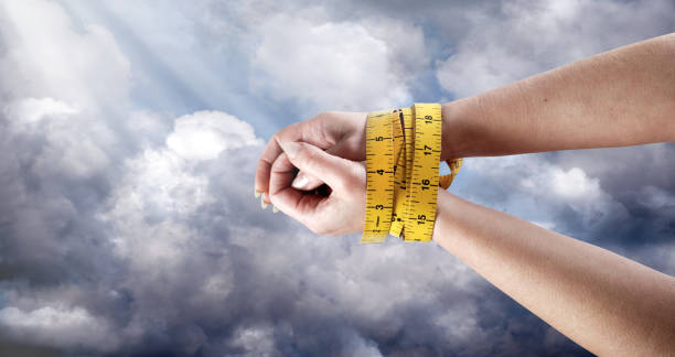 Female hands wrapped around with measuring tape
