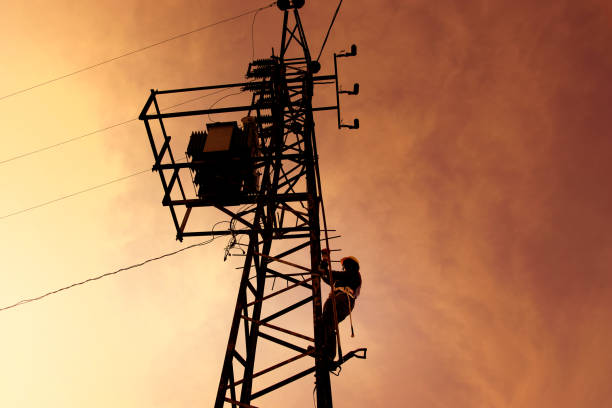 istock Electrician worker climbing electricity pylon over sky 1364722074