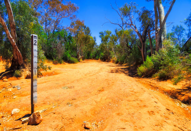 Silverton dry creek soil depth sign Floodway riverbed depth indicator sign post in dry clay soil of arid creek near Silverton town of Australian outback. dry riverbed stock pictures, royalty-free photos & images