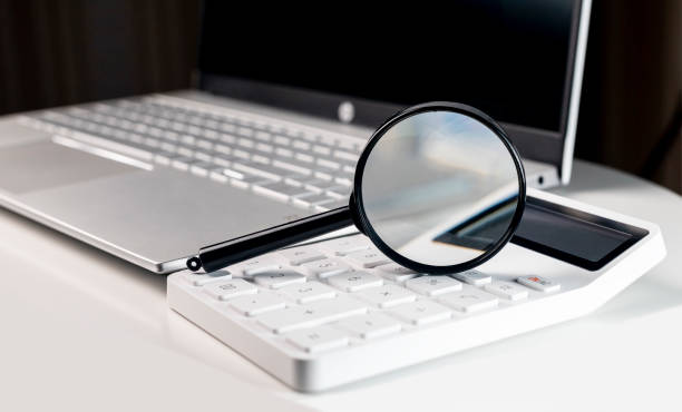 istock Calculator and laptop. Accounting concept with magnifier 1364724871