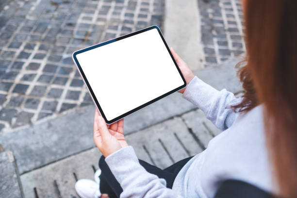 istock Top view mockup image of a woman holding digital tablet with blank white desktop screen 1364725595