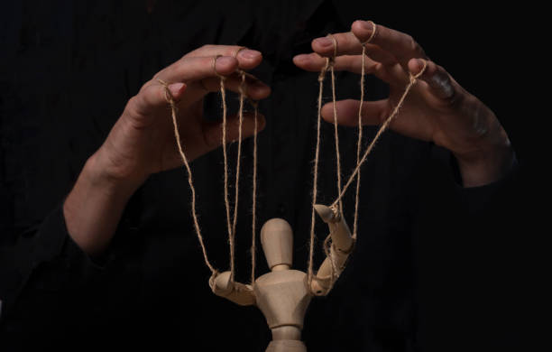 Hands manipulating wood puppet. Master of marionette Hands manipulating wood puppet. Master of marionette. marionette stock pictures, royalty-free photos & images