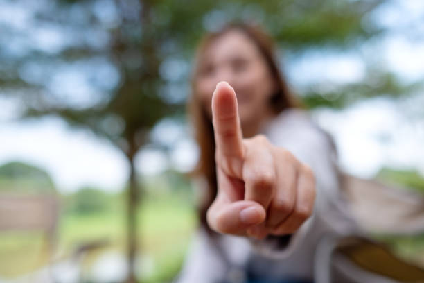 blurred image of a woman touching or pointing finger at you - number 1 businessman one finger one person imagens e fotografias de stock