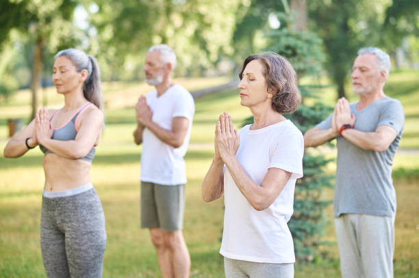 istock Group of people meditating together in park 1364725664