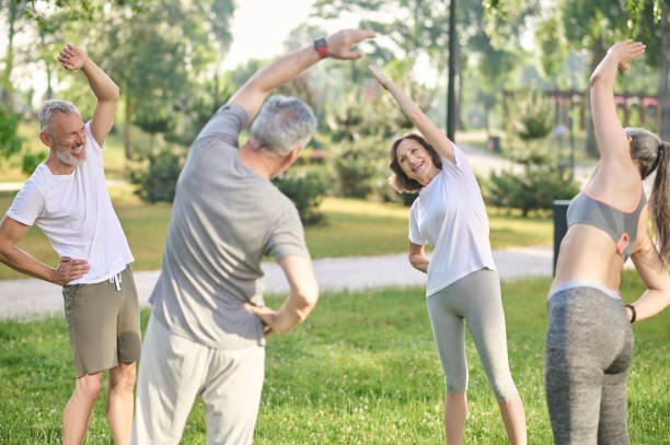 istock Group of people doing morning exercises in the park 1364725735