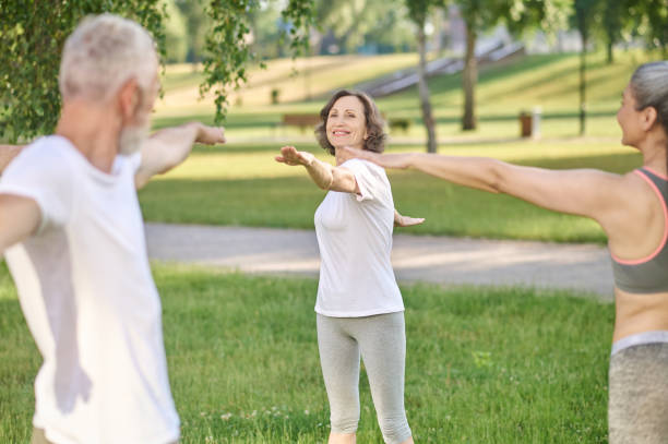 istock Group of people doing morning exercises in the park 1364725745