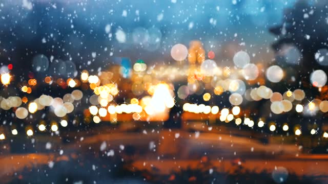 Beautiful snow falling on urban background with colorful bokeh light effect.
