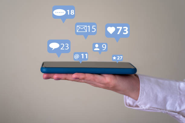 istock The concept of a communication network. A woman's hand holds a phone with pop-up notification icons. 1364725974