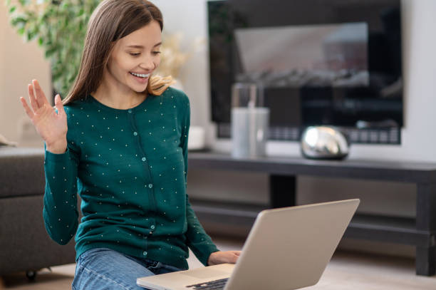 istock Smiling young woman having a video call 1364732441