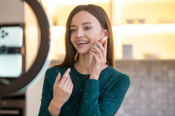 istock Young beautician demonstrating new beauty products during online workshop 1364732564