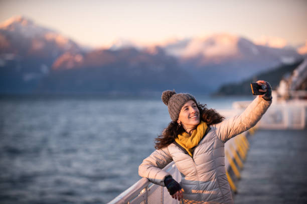 istock Woman taking selfie with mountains and ocean behind her 1364735234