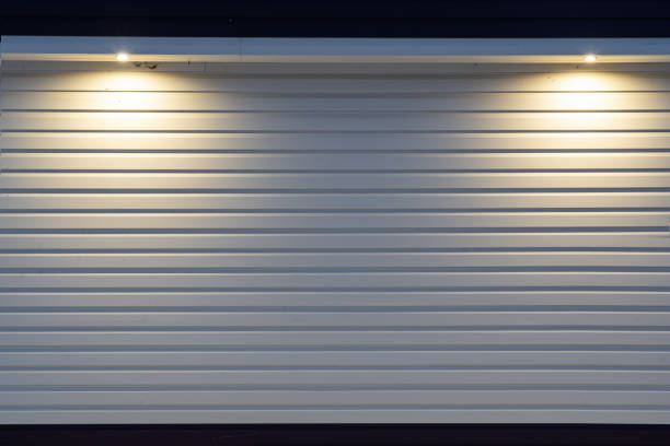 istock The wall of the house is lined with light-colored plastic siding. There is light from two lanterns in the roof visor. Form. Background. Texture. 1364737639