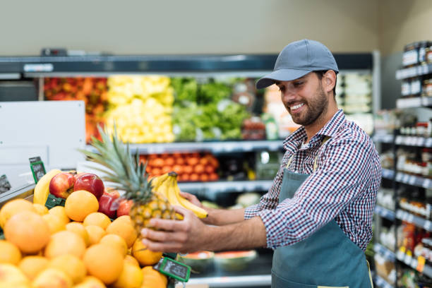 istock Employee in supermarket arranging fresh fruit 1364737781