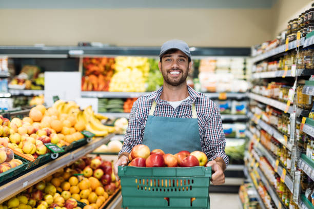 istock Employee in supermarket arranging fresh fruit 1364737842