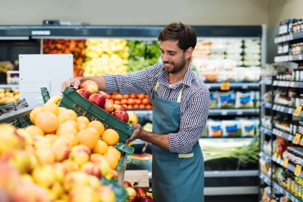 istock Employee in supermarket arranging fresh fruit 1364737964