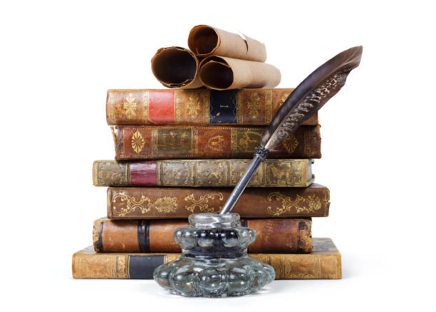 Stack of antique books, inkwell with quill pen and old scrolls, on white background stock photo
