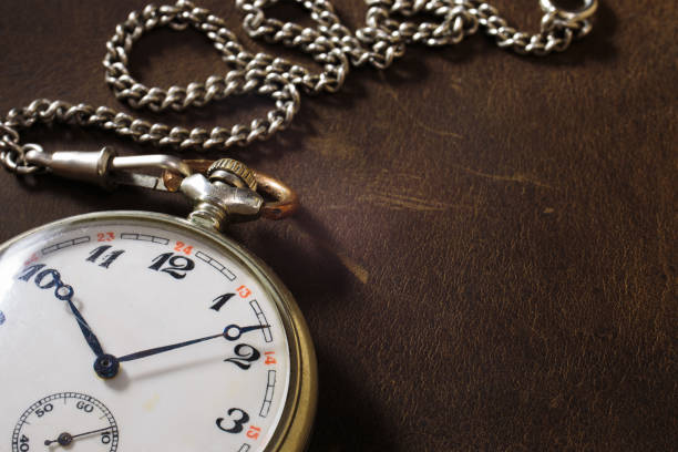 istock Vintage classic antique clock with chain on leather background 1364738184