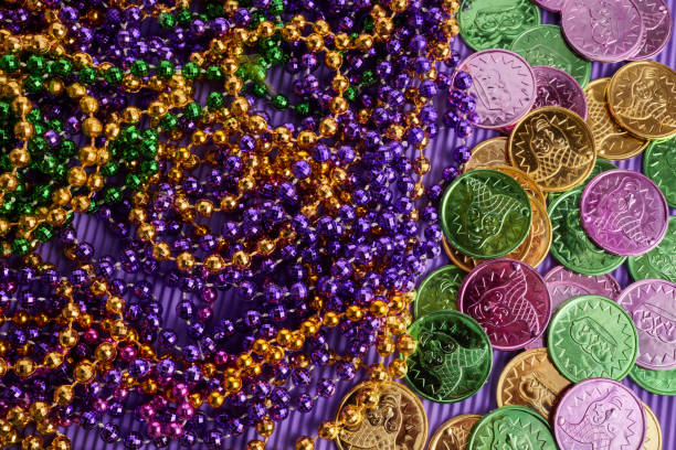Green, gold, and purple Mardi Gras beads and coins background Green, gold, and purple Mardi Gras beads and coins background. purple and gold masquerade masks stock pictures, royalty-free photos & images