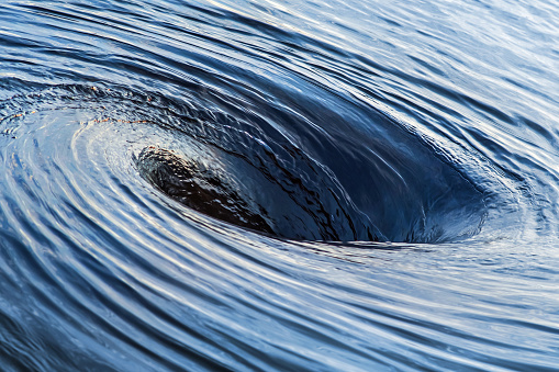 Huge whirlpool on water surface.
