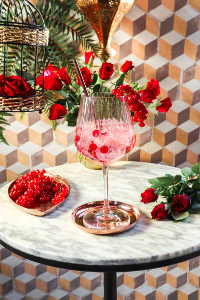 berry spritz tonic cocktail z czerwonymi porzeczkami w marokańskim riadzie i czerwonymi różami na walentynki - flower drink zdjęcia i obrazy z banku zdjęć