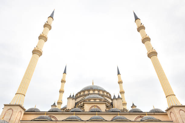 istock Beige minarets of mosque against gray cloudy sky. Copy space. 1364742490