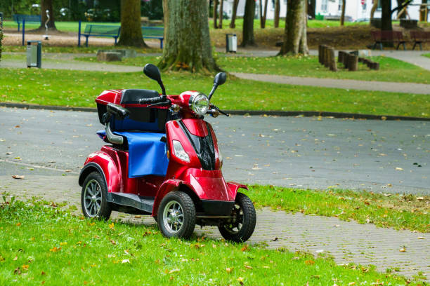 道路脇に立っている四輪の赤いモータースクーター。 - motorcycle handlebar road riding ストックフォトと画像