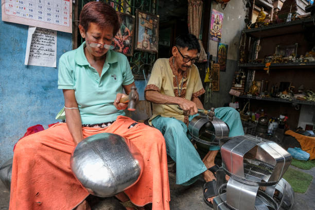 Bangkok, Thailand - January 2022: Craftsmen from the Ban Bat Community making bowls used by Buddhist monks to ask for alms on January 12, 2022 in Bangkok, Thailand.