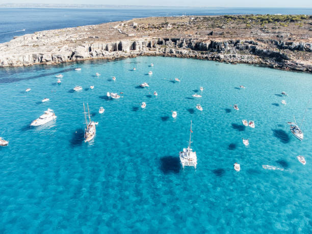 Many boats moored in Cala Rossa, one Favignana Island's beach Many boats moored in Cala Rossa, one Favignana Island's beach. Clear turquoise water. egadi islands photos stock pictures, royalty-free photos & images