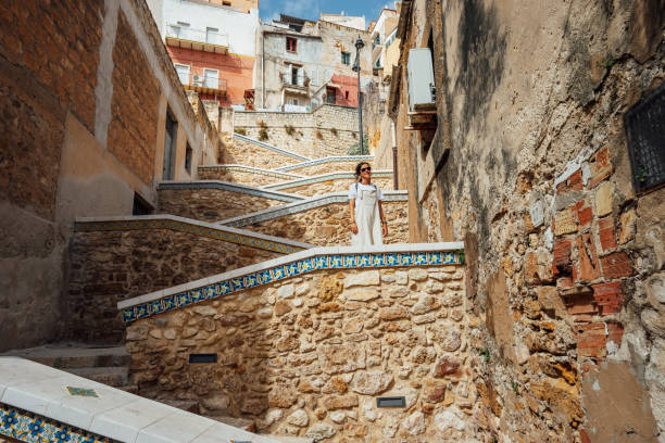 istock A woman is standing on a zig zag staircase in Sciacca, Sicily, Italy 1364745662