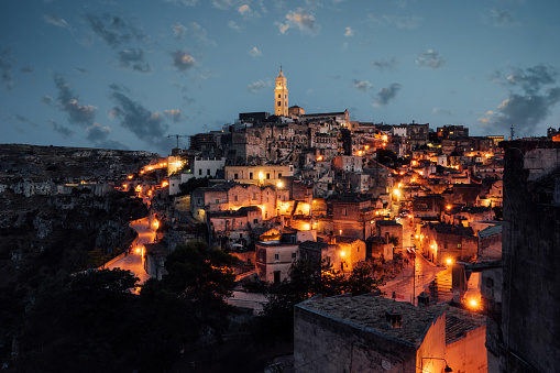 Sassi di Matera panoramic view at sunset with lights of the city. Famous ancient city in Southern Italy.