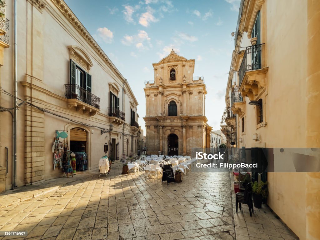 Scicli square at sunset, Sicily, Italy Scicli square at sunset, Sicily, Italy. Scicli is an ancient small village in Sicily, Southern Italy. San Michele Arcangelo Church at sunset, Scicli. Sicily Stock Photo