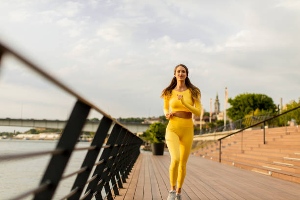 istock Young woman running on the riverside pier 1364746799