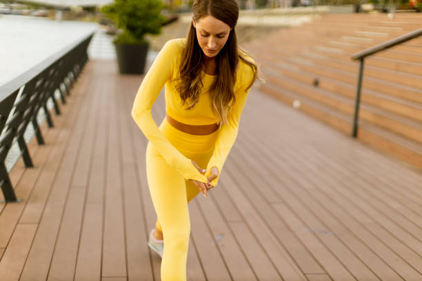 istock Young woman having stretching exercise on the riverside pier 1364746803