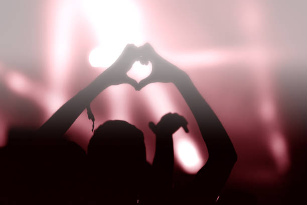 istock Crowd at a music concert, audience raising hands up 1364747698