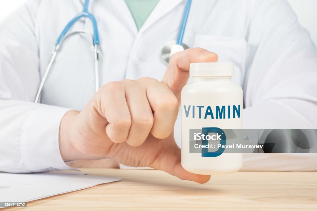 Vitamine D et minéraux essentiels pour l’homme. le médecin recommande de prendre de la vitamine D. le médecin parle des avantages de la vitamine D. D Vitamine - Concept de santé - Photo de Lettre D libre de droits
