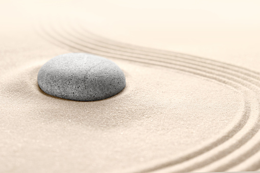 The yin and yang symbol. Balance. Good and evil. Stone garden for meditation. Japanese Zen concept. Buddhism and mindfulness. Concentration and concentration. Round stones on a sandy background. Philosophy