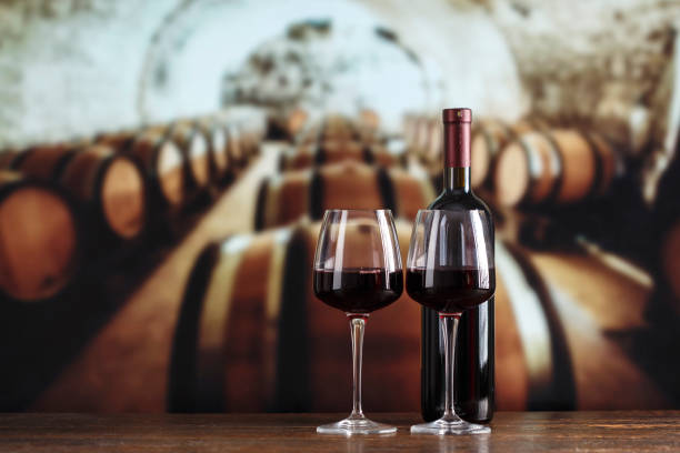 istock Wine cellar with wine bottle and glasses. Red wine tasting in the wine cellar. 1364751046