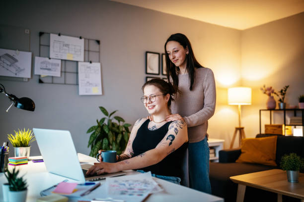 istock Lesbian couple during pandemic using laptop for freelance work and video calls 1364751706