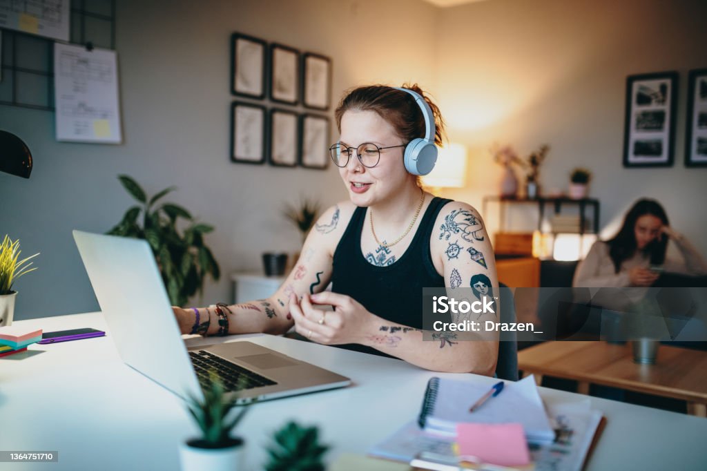 Lesbian couple using laptop for freelance work and video calls Lesbian woman working from home on laptop LGBTQIA People Stock Photo