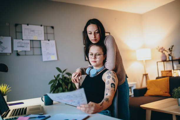 istock Lesbian couple during pandemic using laptop for freelance work and video calls 1364751722