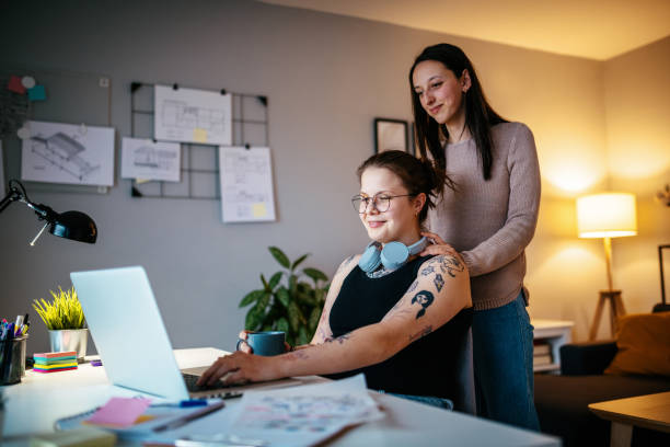 istock Lesbian couple during pandemic using laptop for freelance work and video calls 1364751723