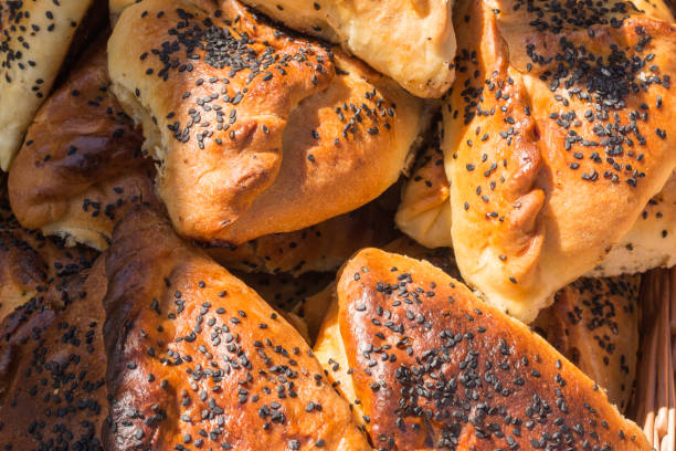 istock Traditional Tatar pie sprinkled with black sesame seeds. Triangular-shaped stuffed cakes. Food background, top view 1364753114