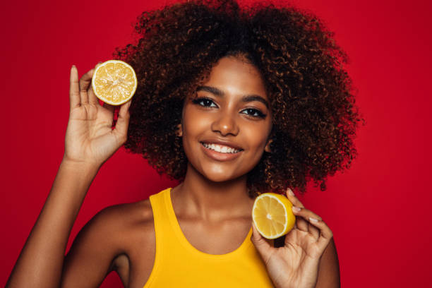 istock Beautiful afro woman holding an orange 1364753740
