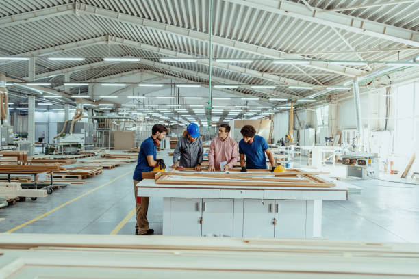 istock Architects, engineers and blue collar staff working together in modern factory 1364753860