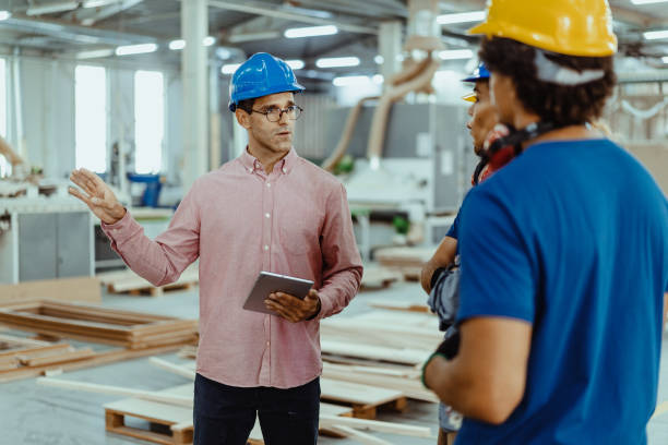 istock Diverse employees in industry - architects, engineers and blue collar staff working together in modern factory 1364753878
