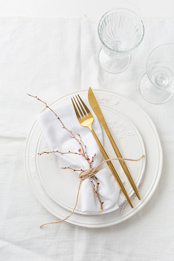 Table setting, empty plate with napkin and cutlery on the on the gray background, top view of the served table decorated with pansies flowers