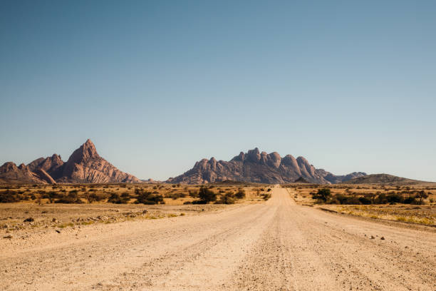 guidare la strada sterrata con vista panoramica sul paesaggio della namibia - extreme terrain foto e immagini stock