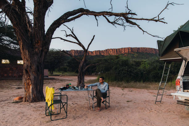 istock Man traveler contemplating sunset camping with mountain view in Namibia 1364754941