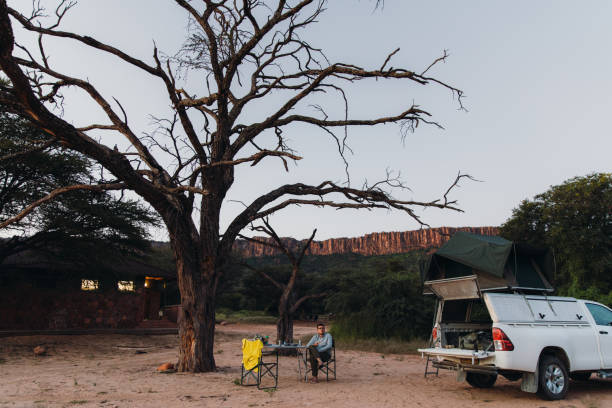 istock Man traveler contemplating sunset camping with mountain view in Namibia 1364754956