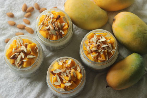 Overnight oats with mango and almonds. Made by soaking rolled oats and chia seeds in milk served with chopped mangoes, almonds and honey